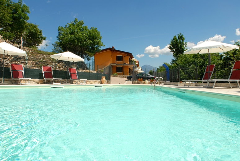 Piscina con edificio e montagne