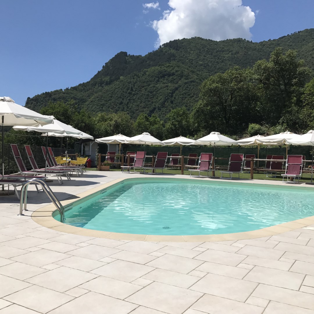 Piscina con sdraio e ombrelloni